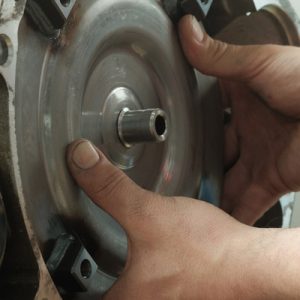 In an automatic transmission, a mechanic with dirty, oil-covered fingernails assembles a new torque converter.