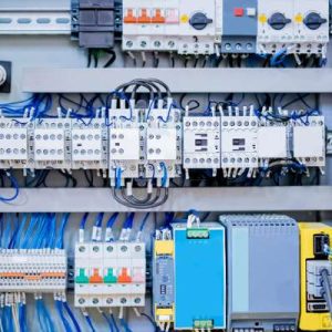 Electrical control panel showing the metal shield and energy distribution system for a CNC machine, including various controllers.