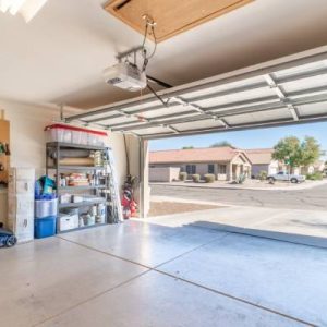 A close-up of a residential home garage. The tools and supplies are neatly organized, and the garage door is open.