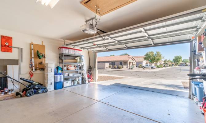 A close-up of a residential home garage. The tools and supplies are neatly organized, and the garage door is open.