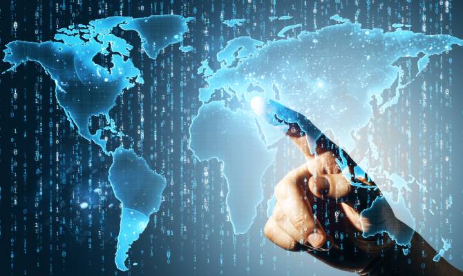 A close-up of a hand pointing at a glowing digital world map on a dark blue background. Binary code floats in the background.
