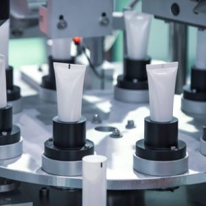 An automatic circular machine holds several blank plastic tubes. More tubes are ready to be implemented in the process.