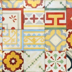 A neat mosaic of several square cement tiles. Each tile boasts intricate patterns in shades of red, yellow, green, and blue.