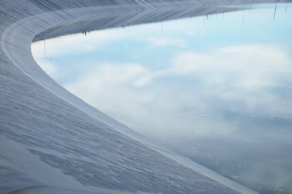 A close-up of the water line inside a tank lining material made of black high-density polyethylene.