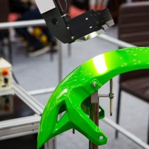 A lime green part is attached to a mount. A robotic arm hovers over the part collection data points.